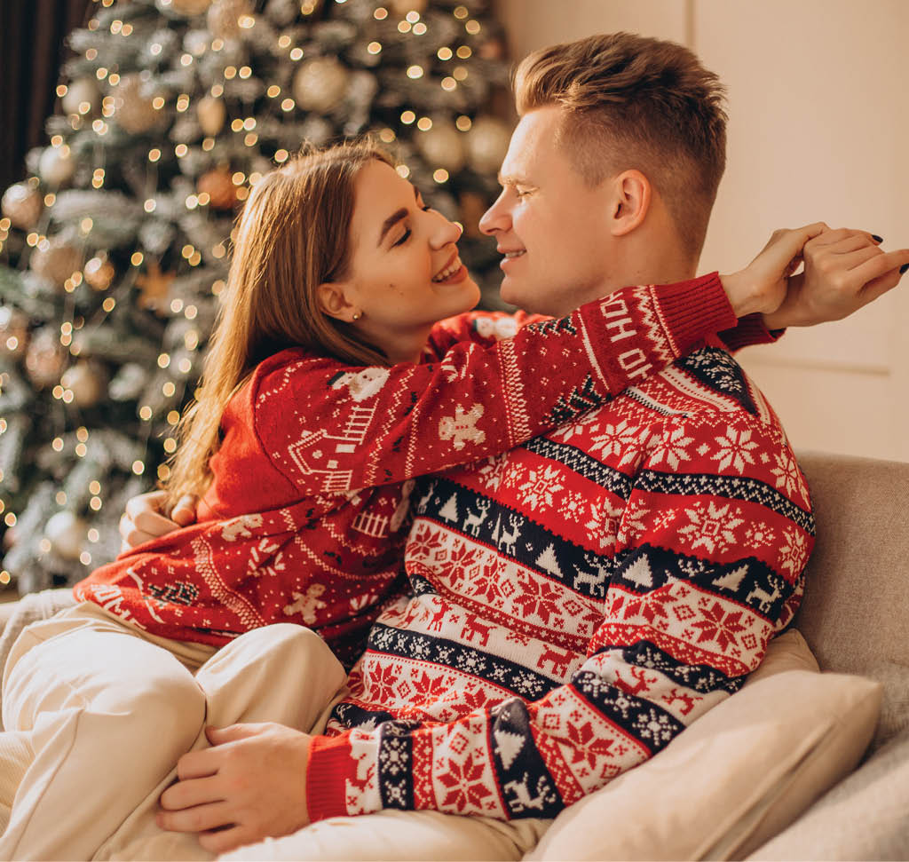 Couple sitting on coach together by the Christmas tree