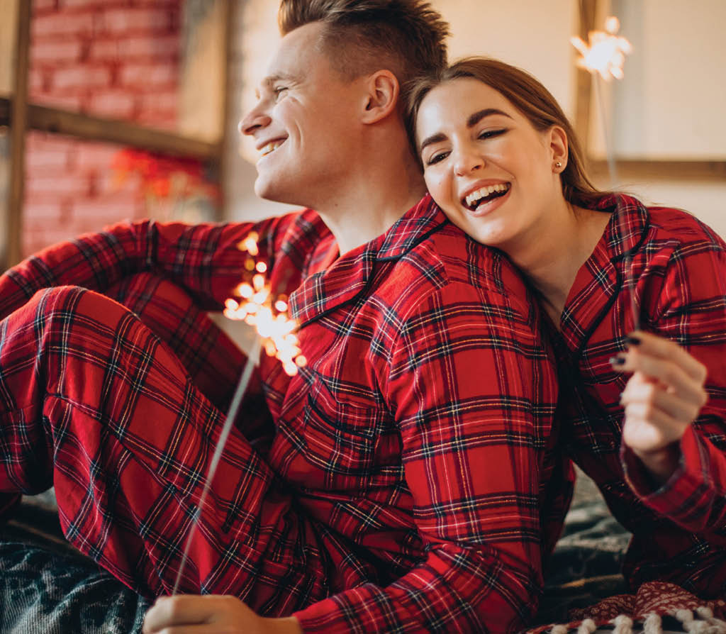 Young couple with bengal lights celebrating