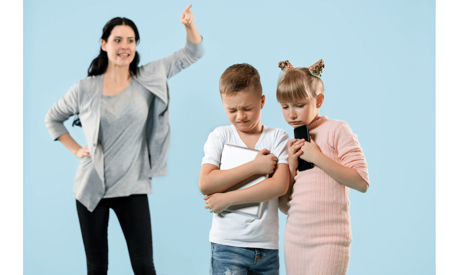 Angry mother scolding her son and daughter at home  Studio shot of emotional family  Human emotions, childhood, problems, conflict, domestic life, relationship concept