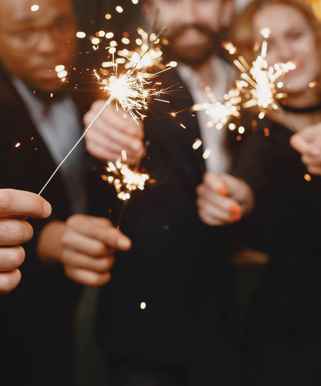 People in a Christman decorations  Man in a black suit  Group celebrations New Year  People with bengal lights 