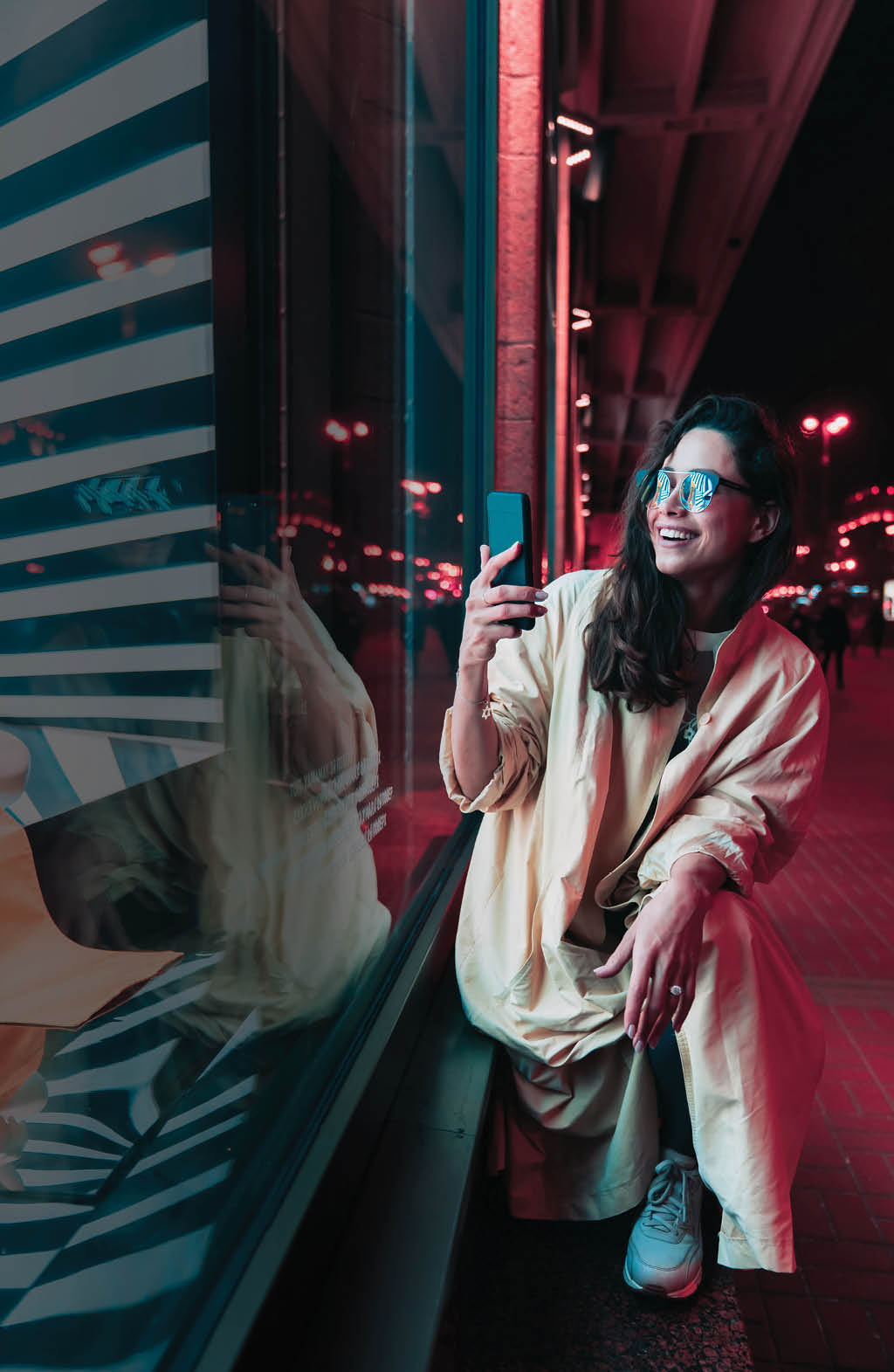 Night in the city, beautiful woman among red lights  Sexy young beauty woman posing over night city street background
