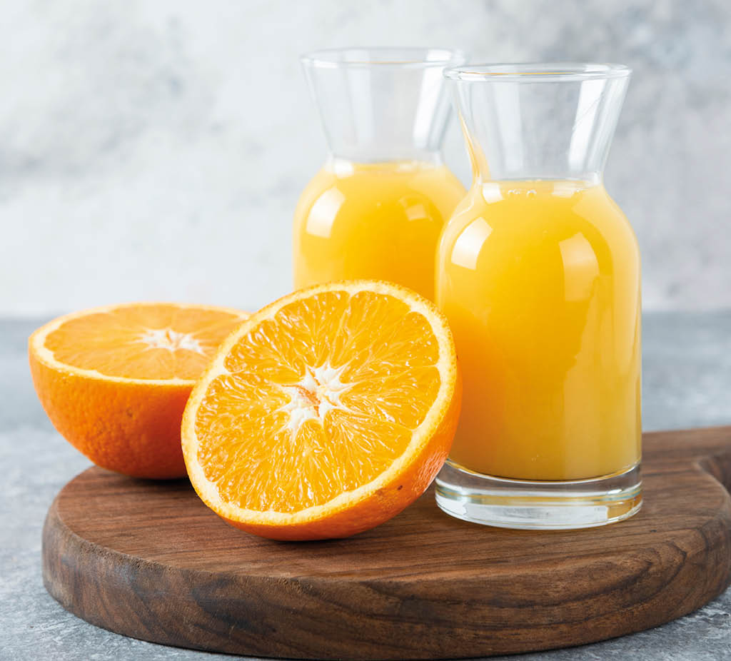 Glass pitchers of juice with slice of orange fruit . High quality photo