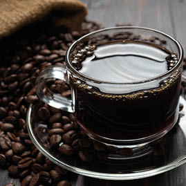 Hot coffee in a glass on the wooden table.