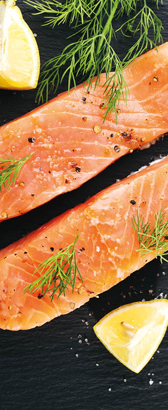 Raw fresh tasty salmon steaks placed on black slate with ingredients. Ready to cook. Slate background. Horizontal with copy space
