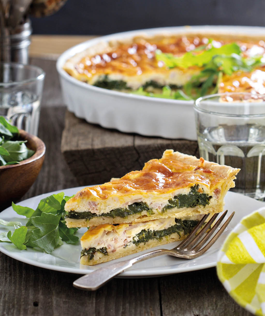 Quiche with cheese, arugula and bacon on a table