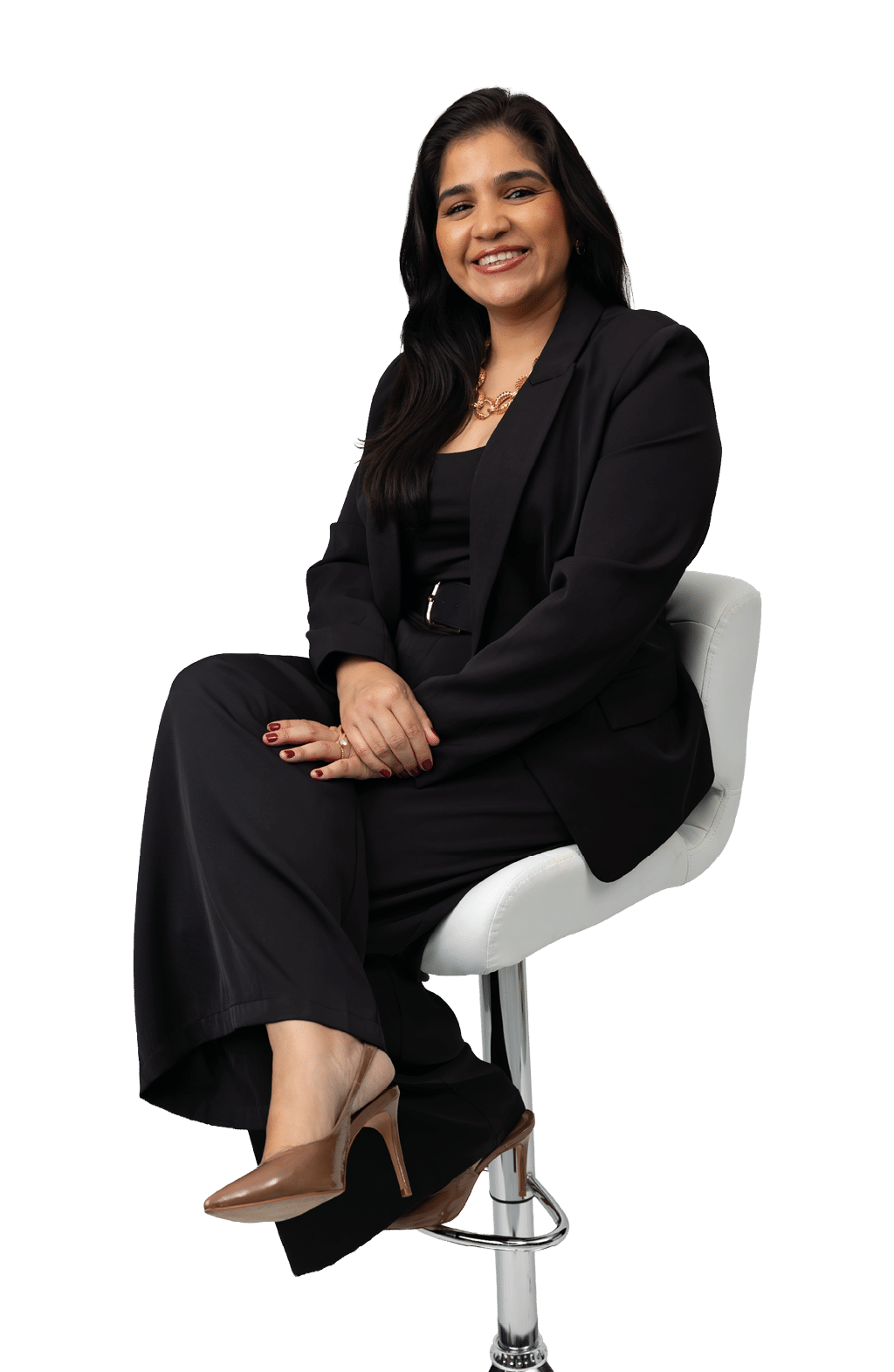 Persona adulta con cabello largo y oscuro, vestida con traje negro y zapatos de tac n marrones, sentada y sonriendo en una silla blanca alta. Descripci n generada con IA