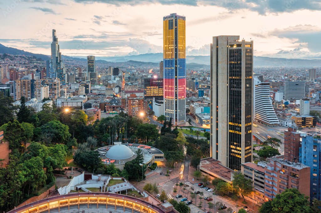 Ciudad con numerosos edificios residenciales y comerciales bajo un cielo parcialmente nublado con tonos azules y blancos. Descripci n generada con IA