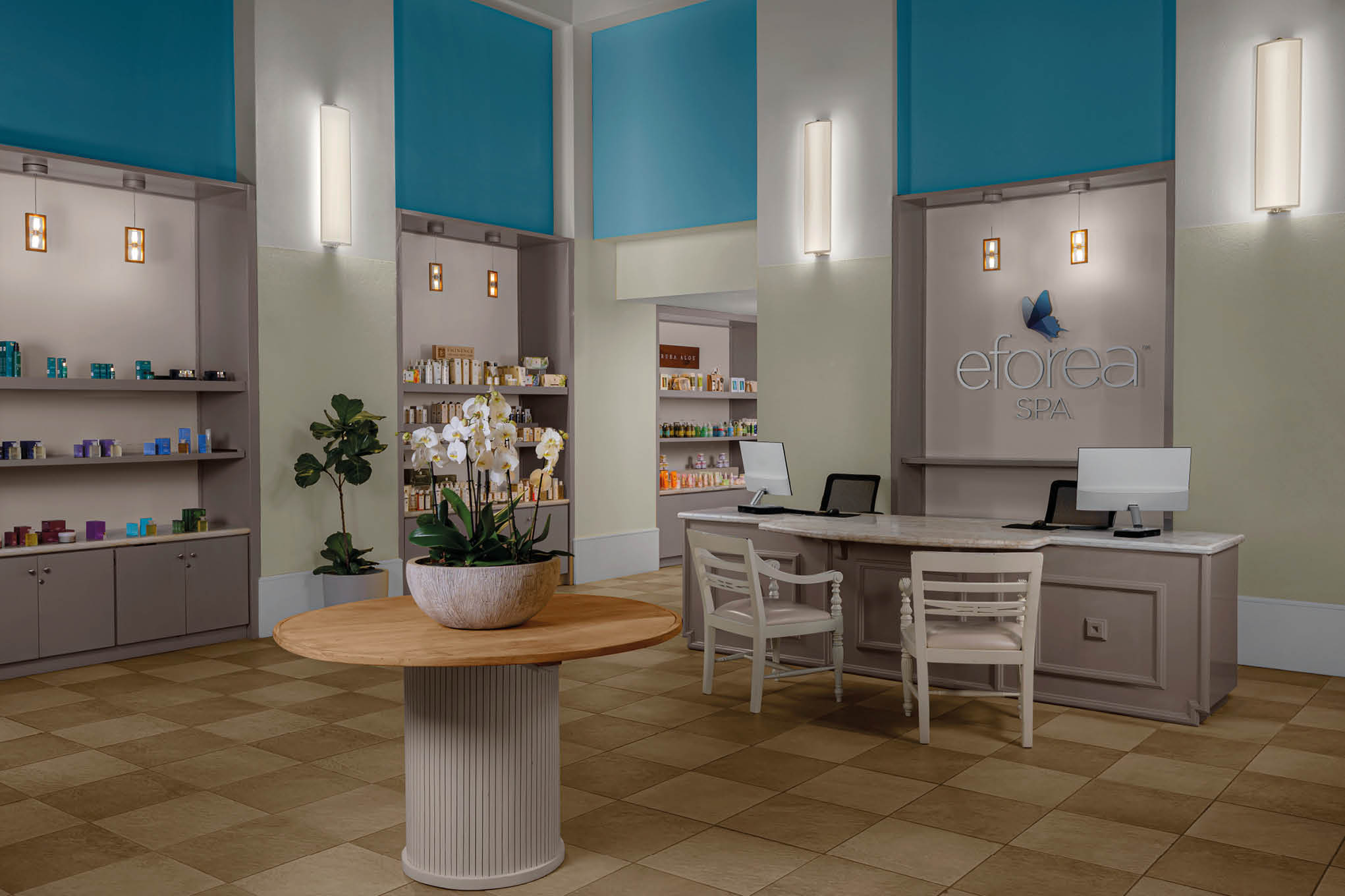 Recepci n de un spa con mostrador, dos sillas, estanter as con productos y una mesa redonda con plantas decorativas en un ambiente moderno y luminoso. Descripci n generada con IA