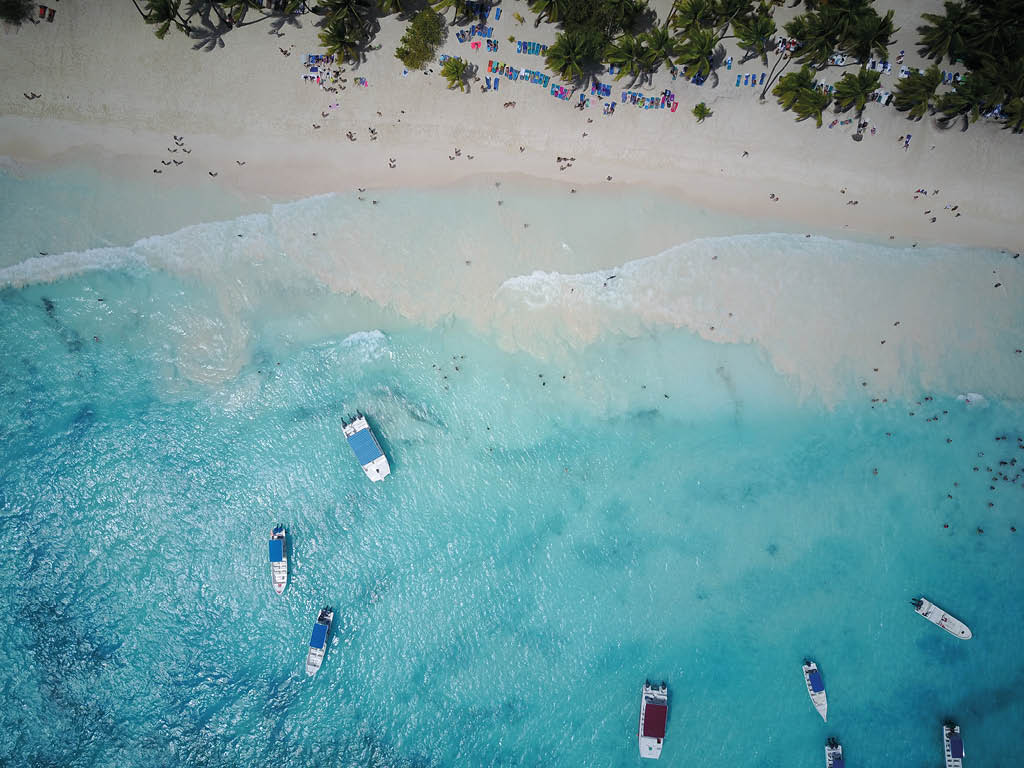Look from above at turquoise water along golden beach somewhere in Dominican Republic