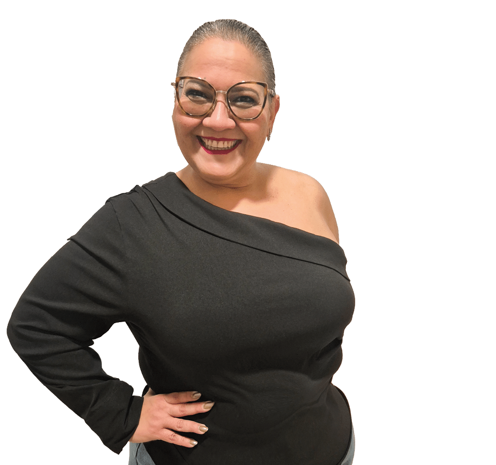 Persona con gafas y cabello recogido que sonr e mientras posa con una mano en la cadera vistiendo un su ter negro de un hombro y pantalones de mezclilla. Descripci n generada con IA
